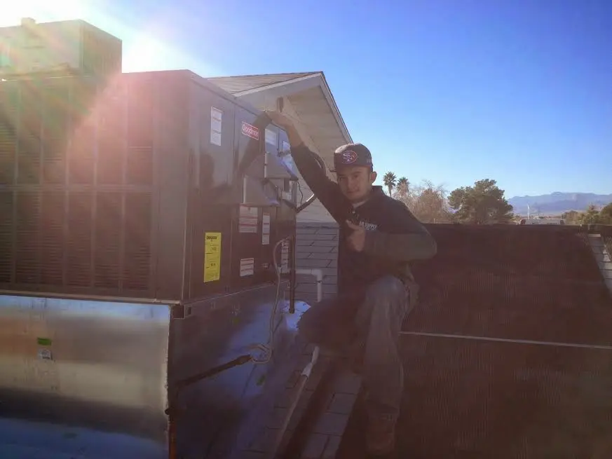 HVAC technician performing Heat Pump Repair on a rooftop unit in Dunn